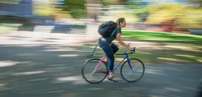 Student riding a bike on campus